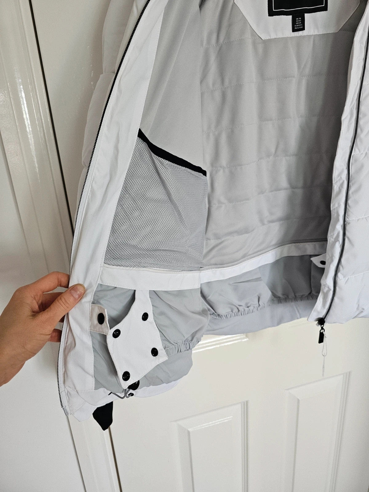 Dare2b white ski jacket with removable faux-fur hood, adjustable hem, and multiple pockets.