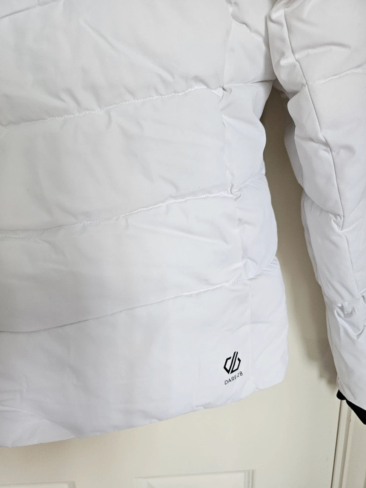 Dare2b white ski jacket with removable faux-fur hood, adjustable hem, and multiple pockets.