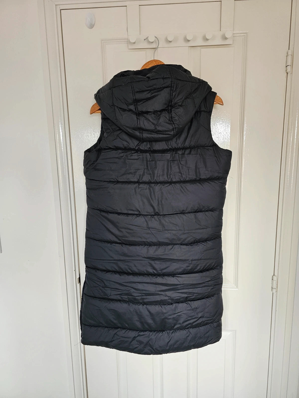 Dare2b black longline hooded puffer gilet with zipper, waterproof and windproof design.
