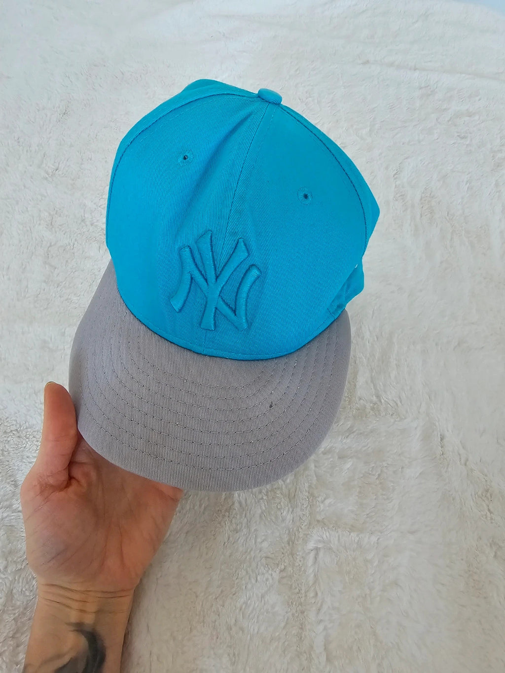 New Era blue snapback cap with NY logo applique and adjustable cotton straps.