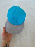 New Era blue snapback cap with NY logo applique and adjustable cotton straps.