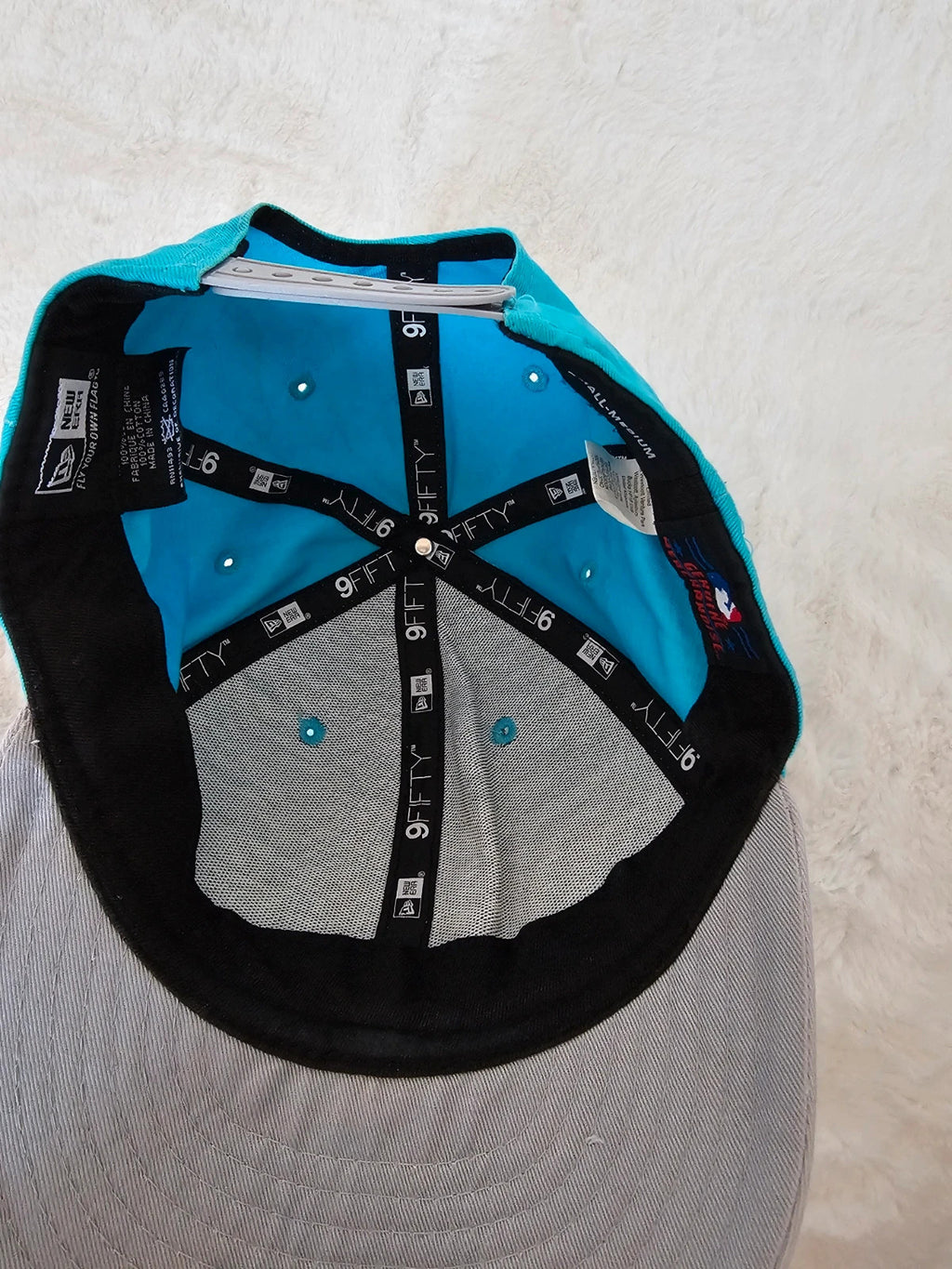New Era blue snapback cap with NY logo applique and adjustable cotton straps.