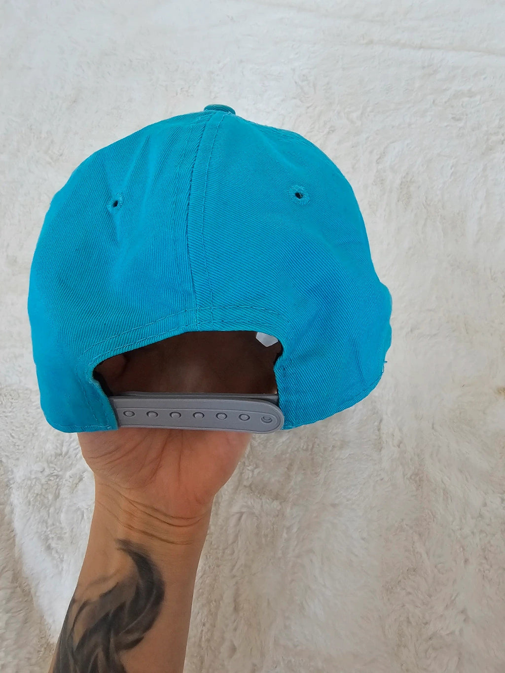 New Era blue snapback cap with NY logo applique and adjustable cotton straps.