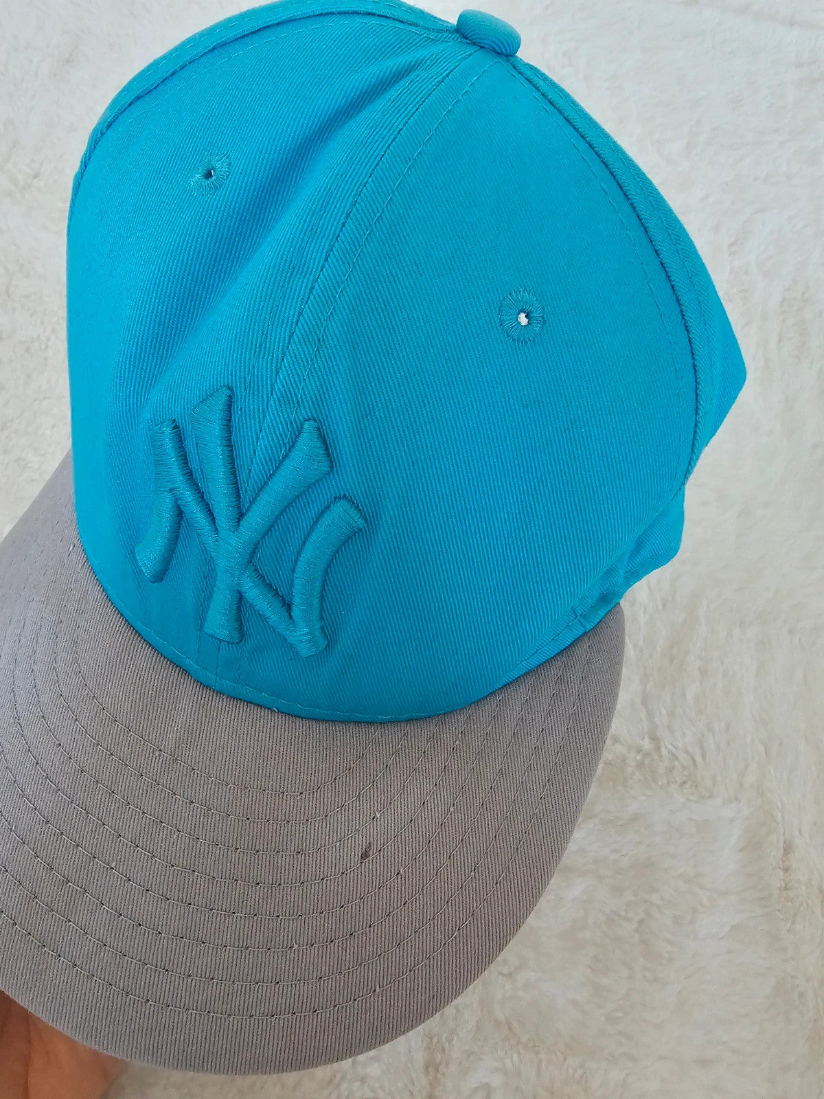 New Era blue snapback cap with NY logo applique and adjustable cotton straps.