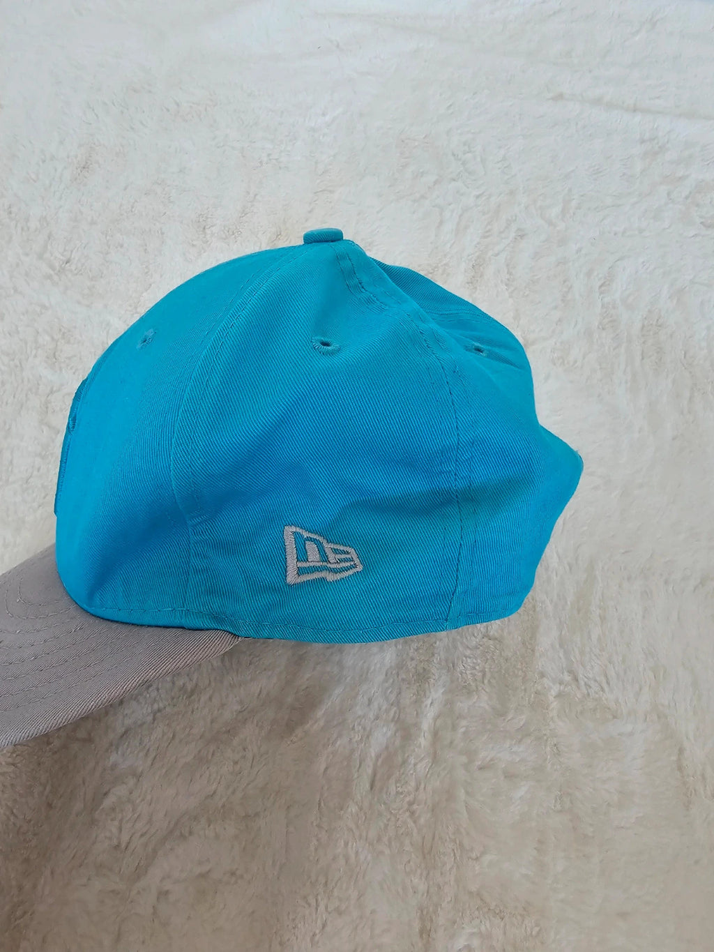 New Era blue snapback cap with NY logo applique and adjustable cotton straps.