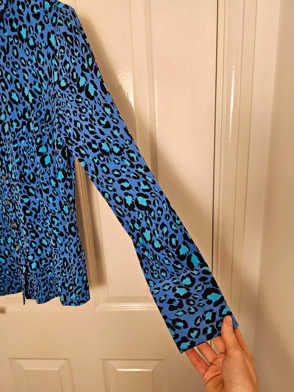 Ruth Langsford blue and black leopard print blouse with collar and button details.