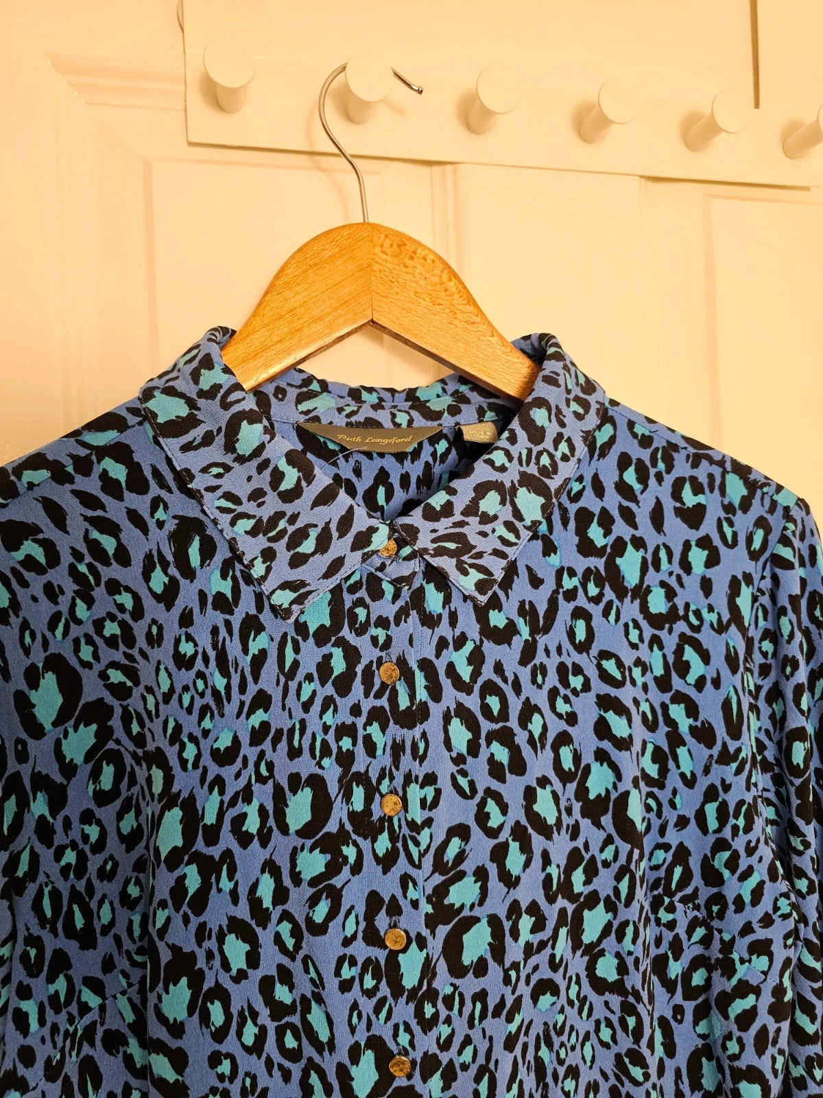 Ruth Langsford blue and black leopard print blouse with collar and button details.