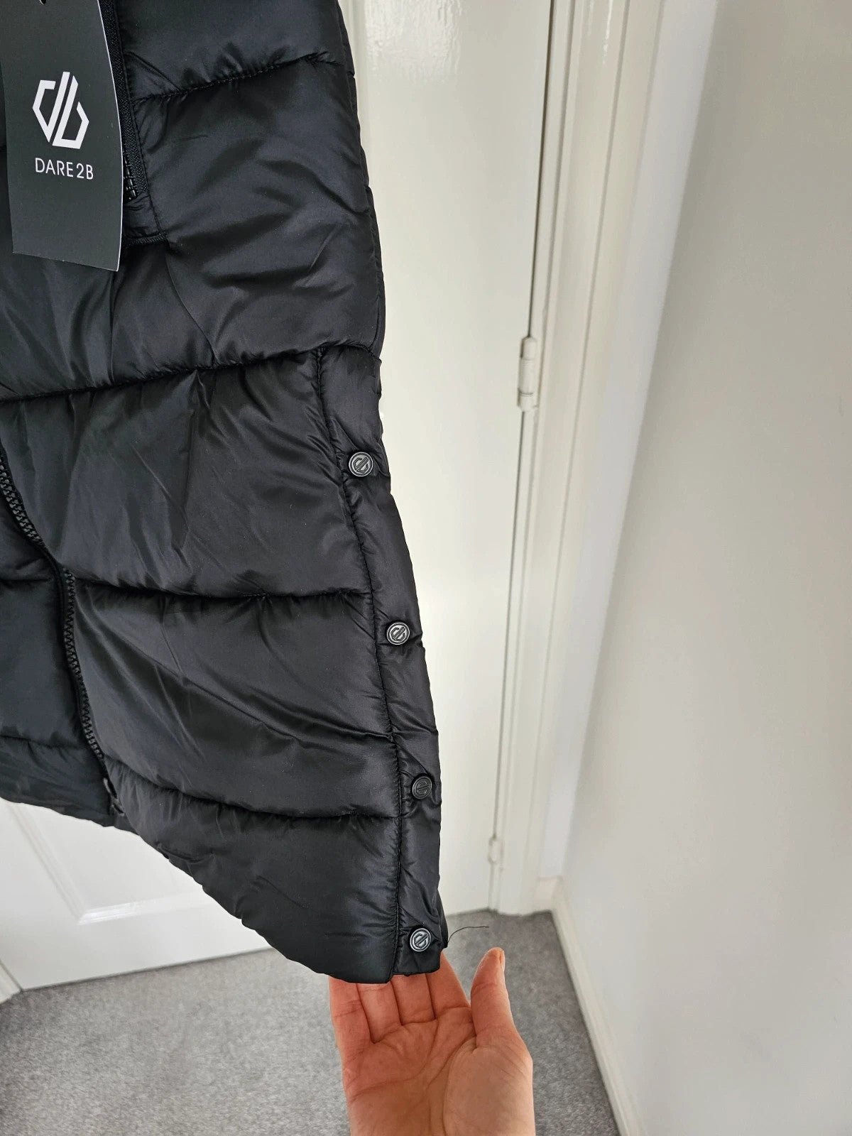 Dare2b black longline hooded puffer gilet with zipper, waterproof material, sleeveless design.