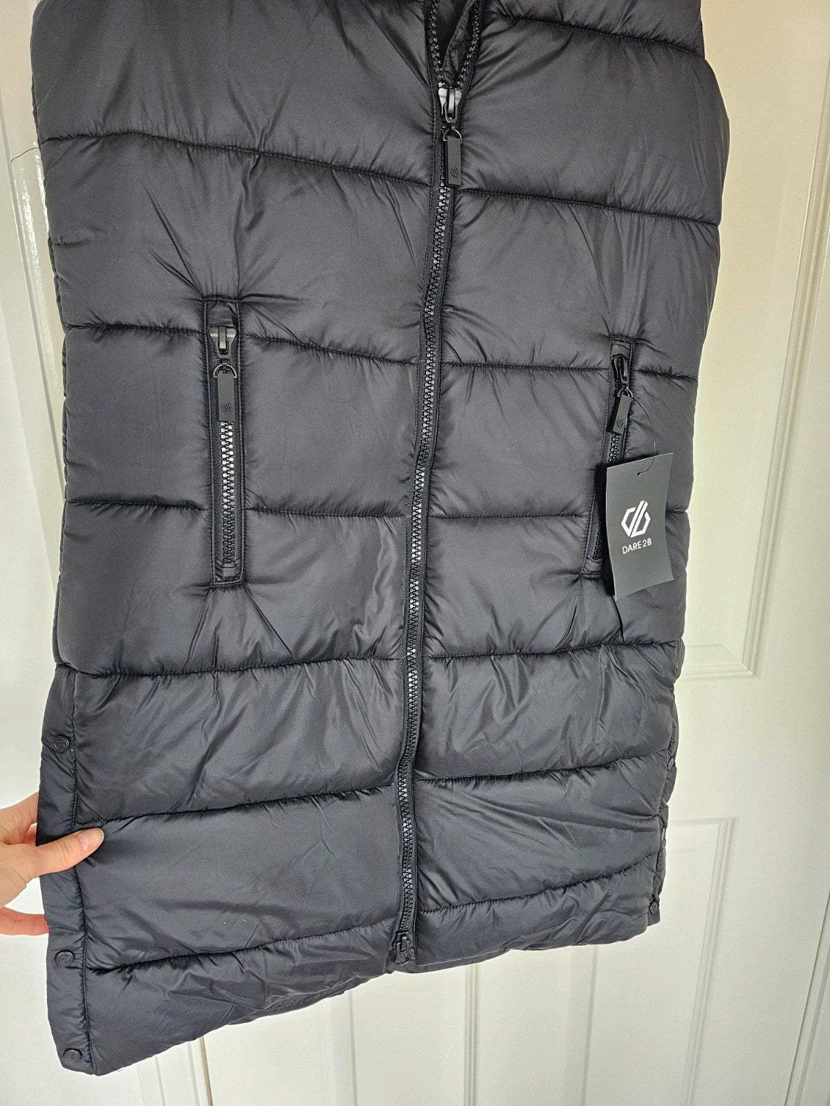 Dare2b black longline hooded puffer gilet with zipper, waterproof material, sleeveless design.