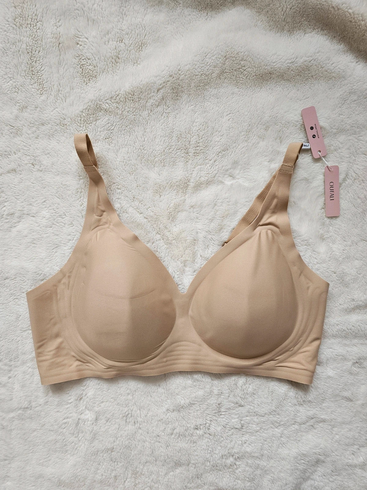 Oufali beige wireless bra seamless design with tag, no underwire for comfort.