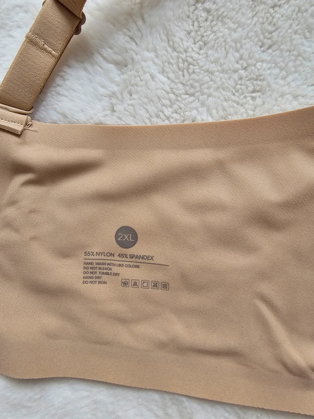 Oufali beige wireless bra seamless design with tag, no underwire for comfort.