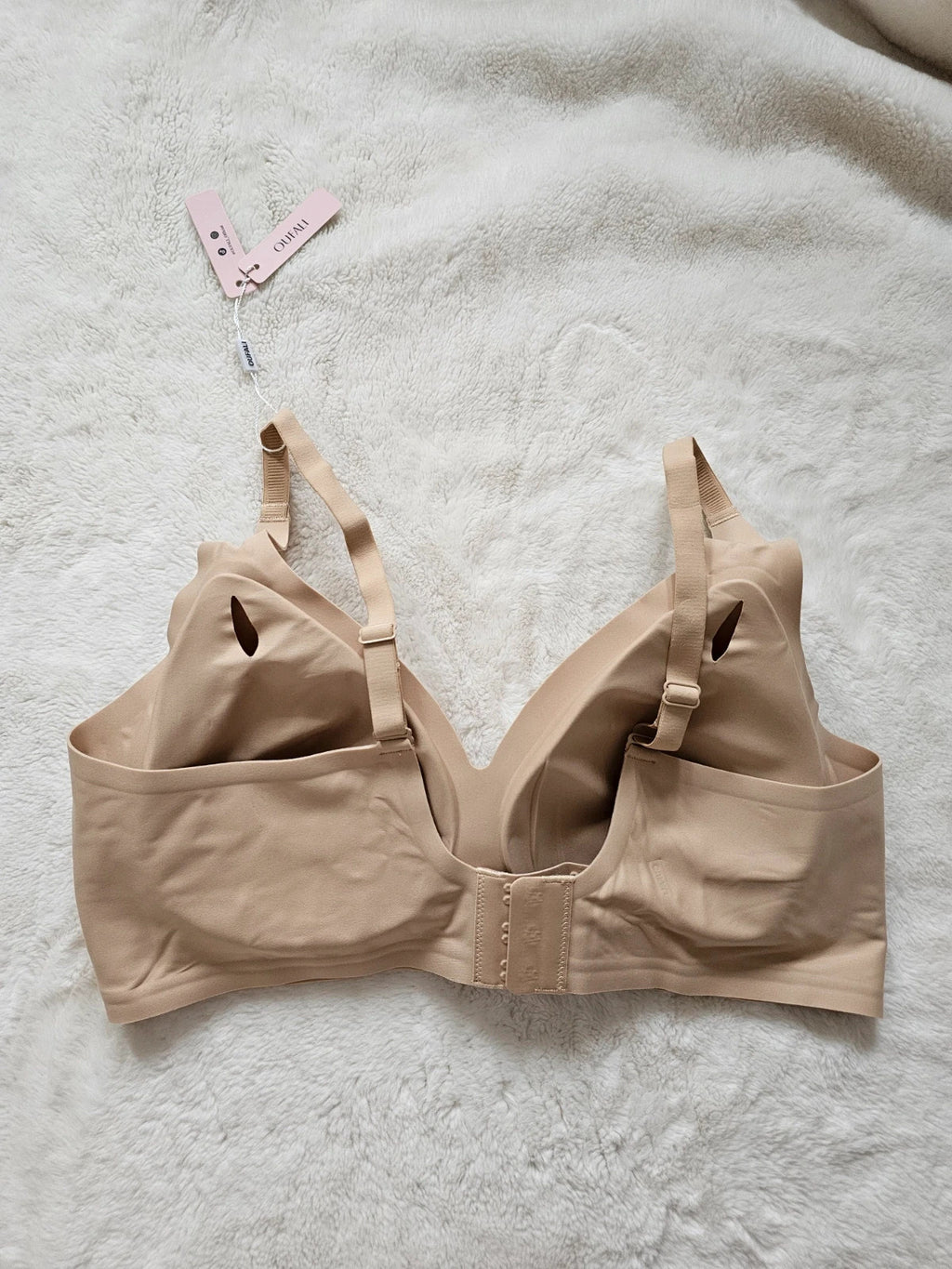 Oufali beige wireless bra seamless design with tag, no underwire for comfort.