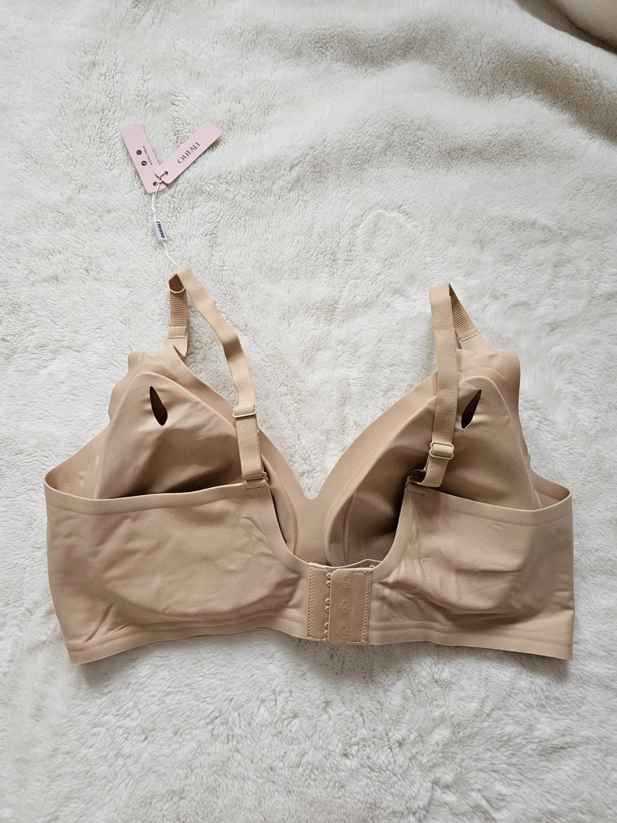 Oufali beige wireless bra seamless design with tag, no underwire for comfort.