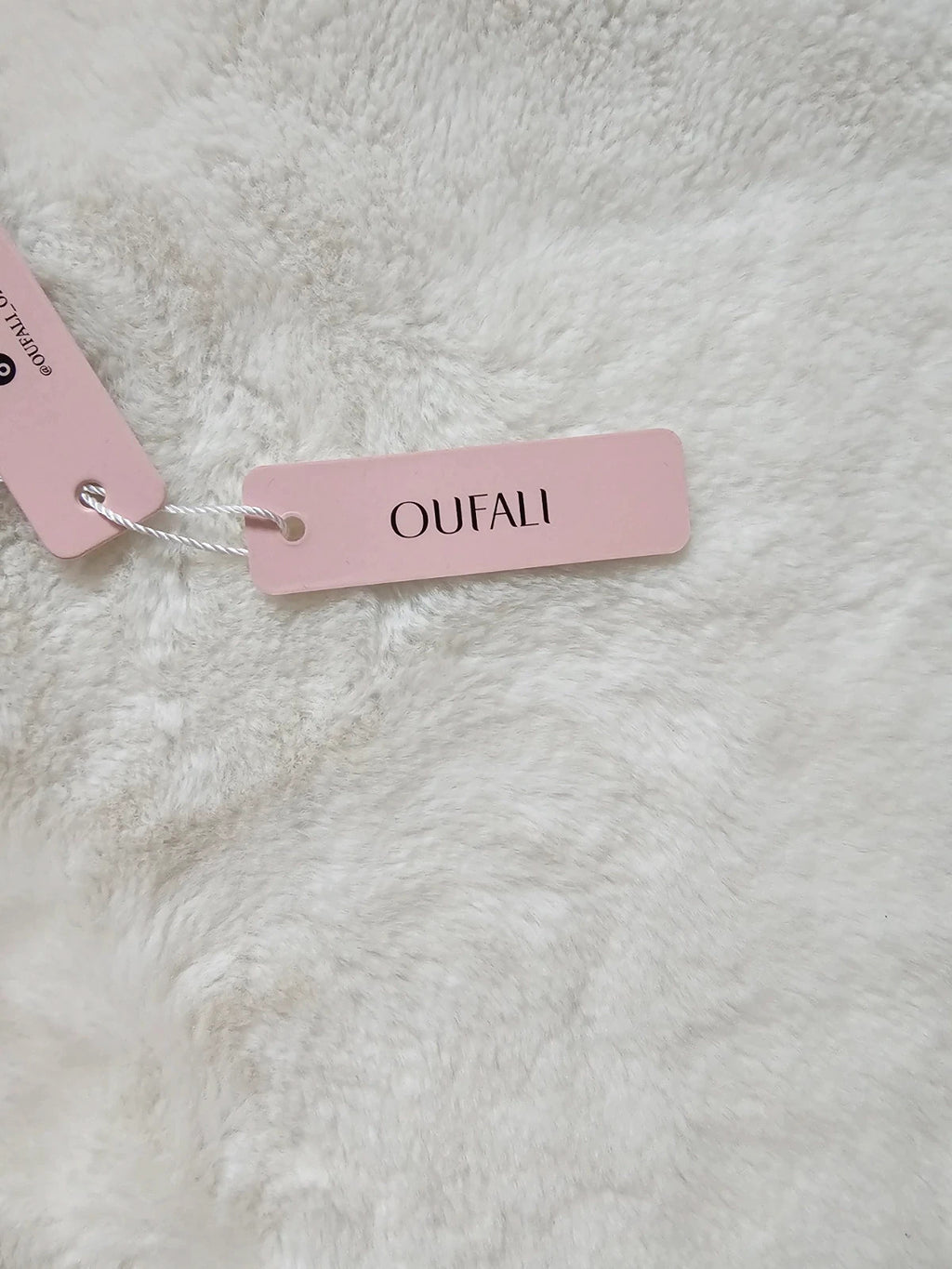 Oufali beige wireless bra seamless design with tag, no underwire for comfort.
