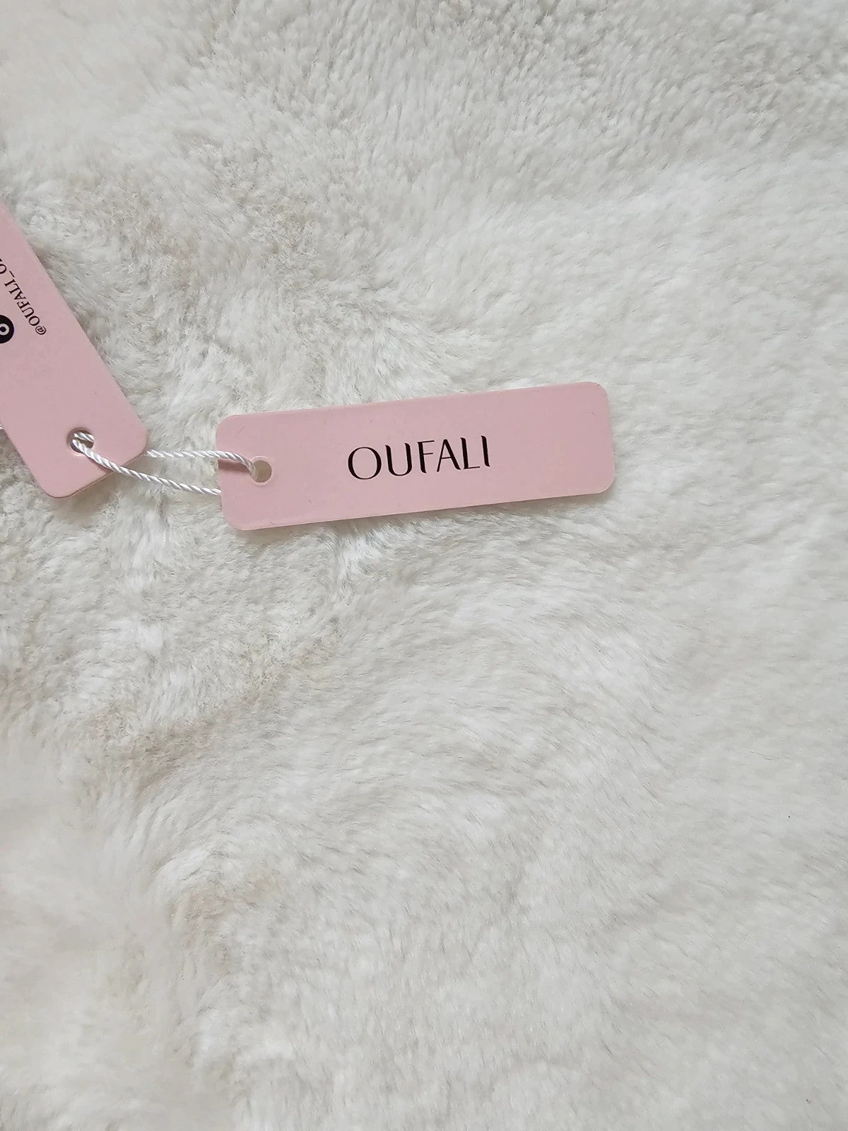 Oufali beige wireless bra seamless design with tag, no underwire for comfort.
