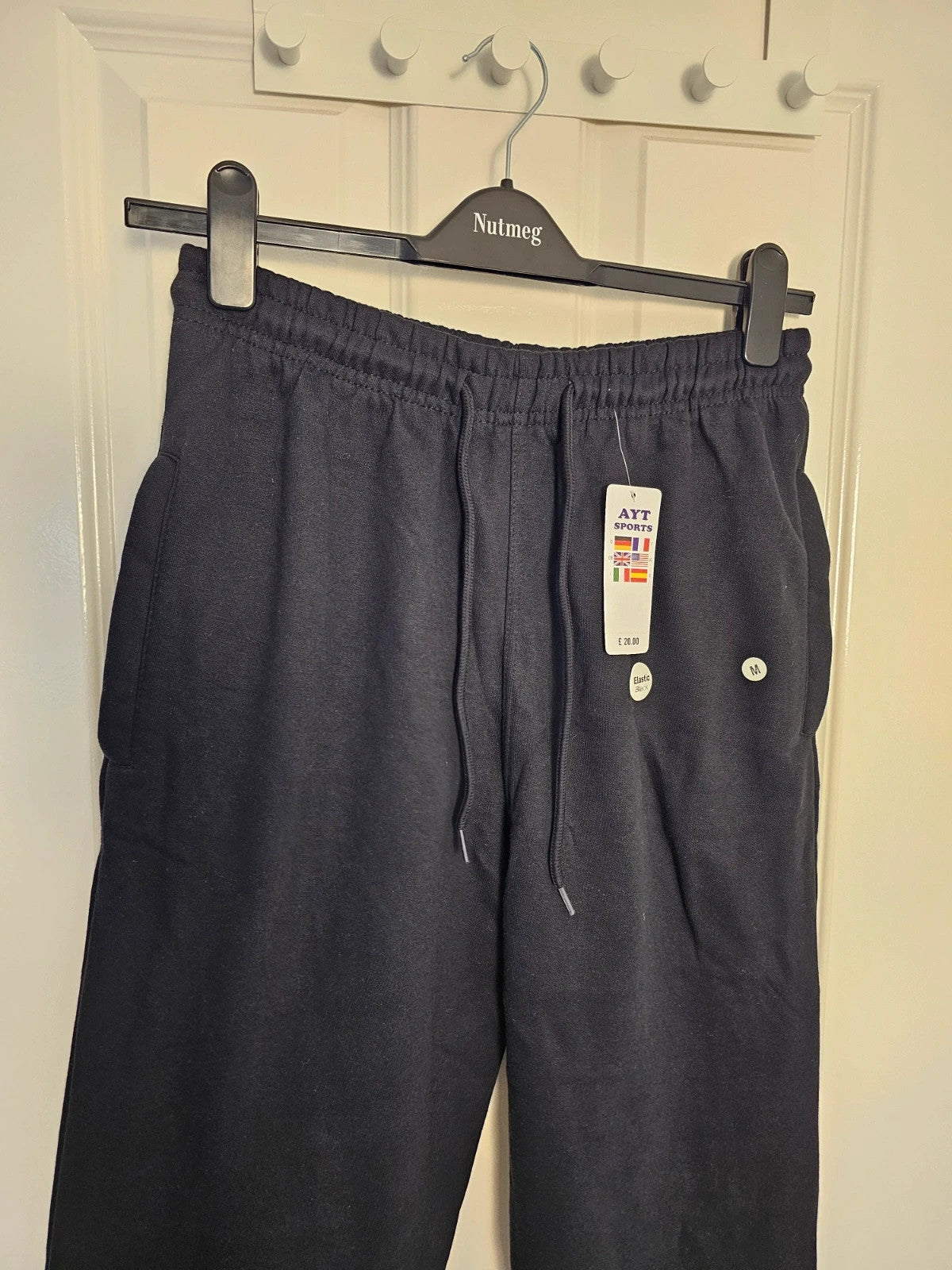 Sports black joggers with elastic waist, drawstring, and side pockets, cotton blend.