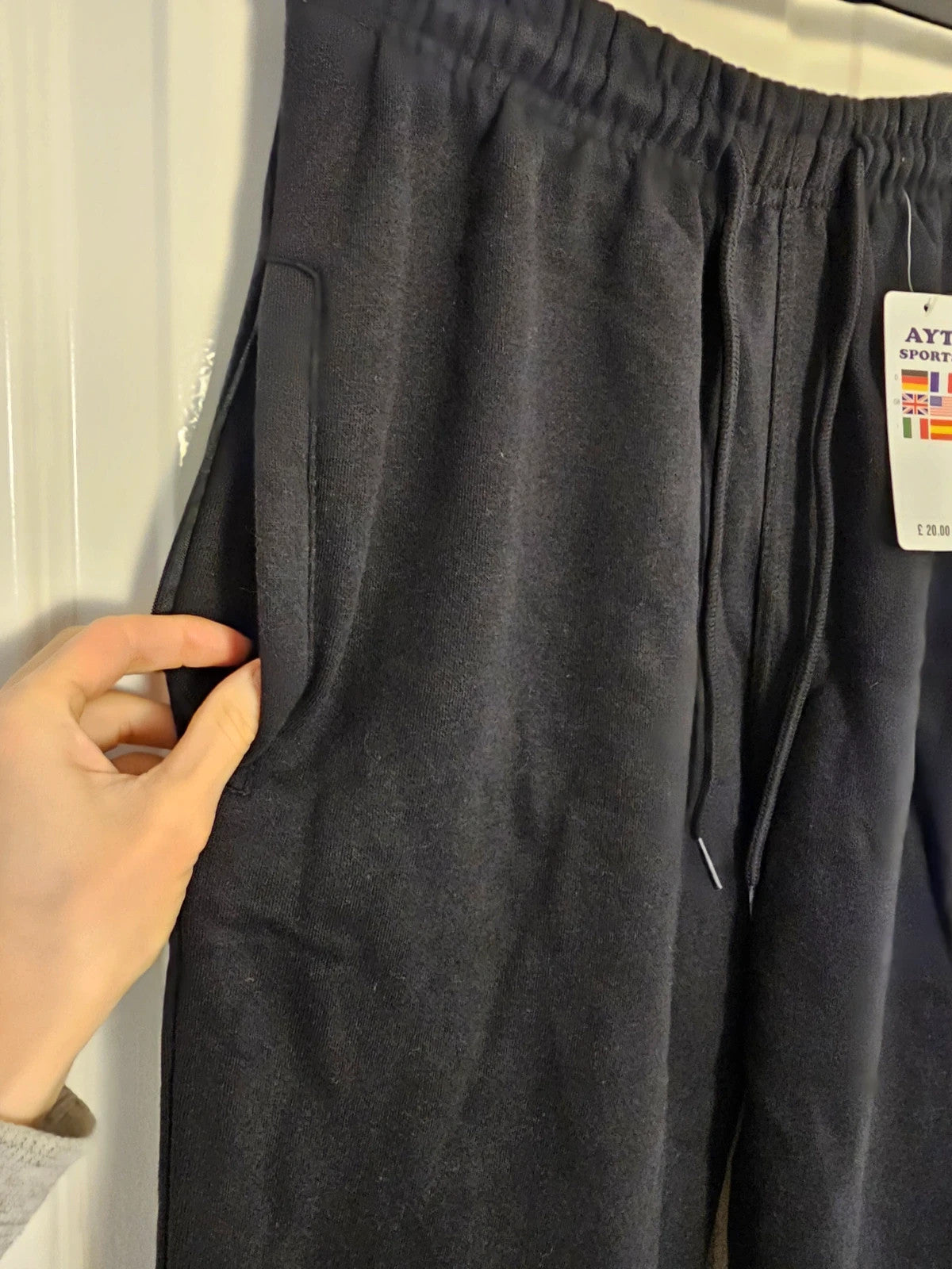 Sports black joggers with elastic waist, drawstring, and side pockets, cotton blend.