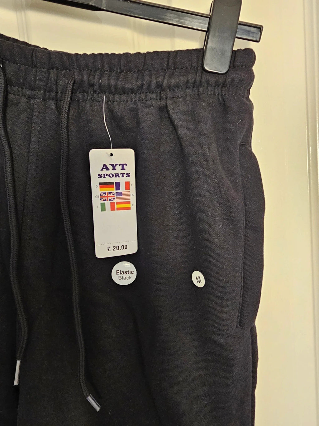 Sports black joggers with elastic waist, drawstring, and side pockets, cotton blend.