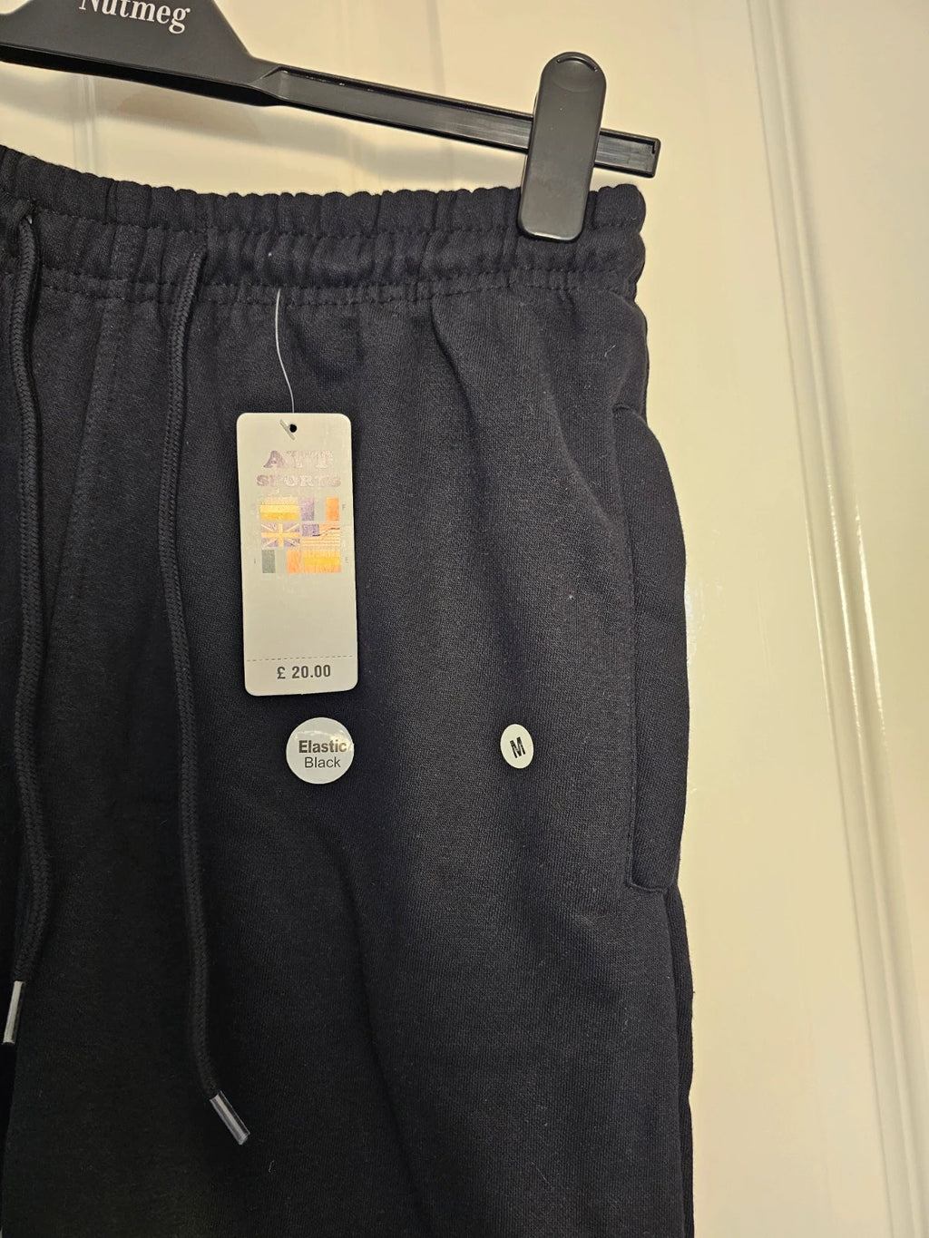 Sports black joggers with elastic waist, drawstring, and side pockets, cotton blend.