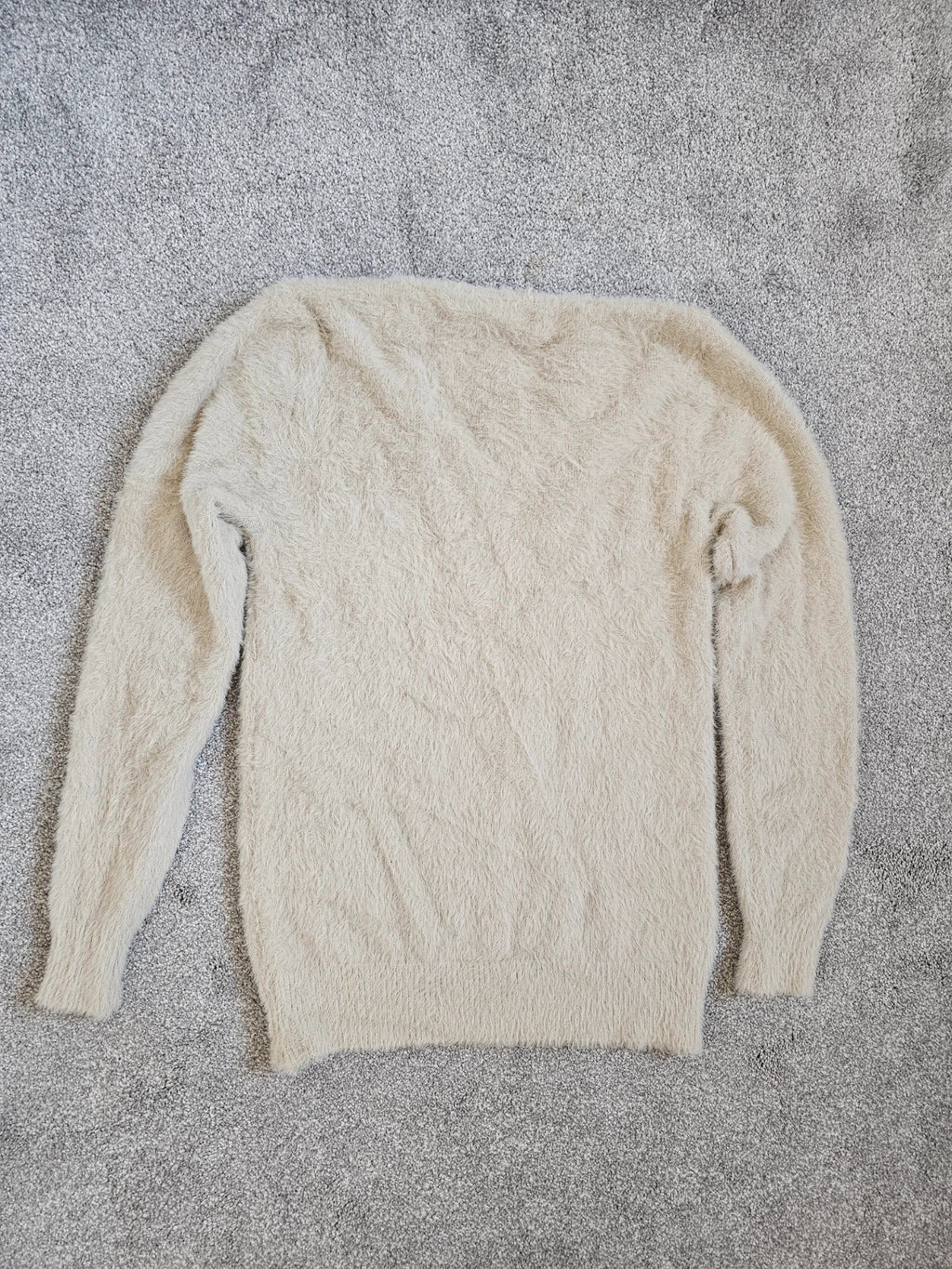 Generic cream fluffy knitted V-neck jumper with long sleeves and soft texture.