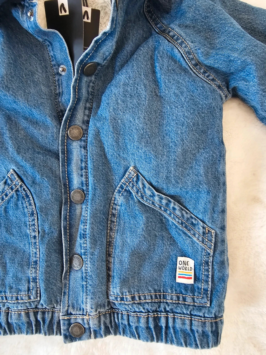 TU Kids blue denim sherpa jacket with outer collar, buttons, and pockets.