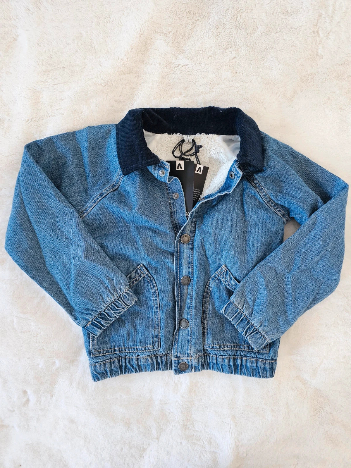 TU Kids blue denim sherpa jacket with outer collar, buttons, and pockets.